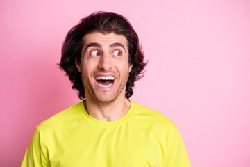 Photo portrait of amazed shocked man in green clothes looking curious empty space isolated on pastel pink color background