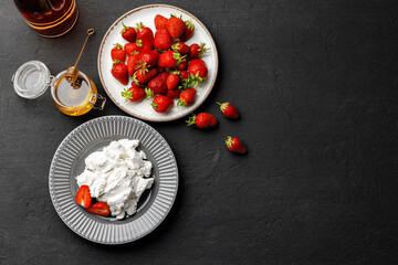 Fototapeta na wymiar Cream cheese and fresh strawberries on black background