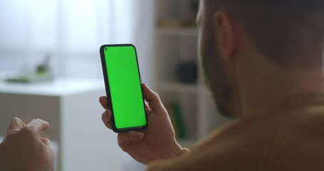 communication by app in smartphone, video call on green screen, man is talking and looking on display, closeup - Powered by Adobe