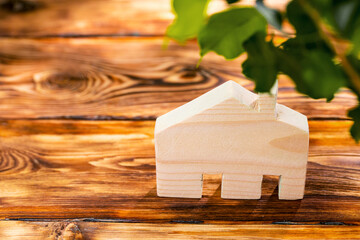 Wooden house miniature on wooden surface close up