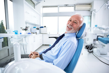 Elderly man in dentist's chair without fear waiting for treatment
