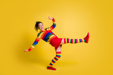 Fototapeta na wymiar Profile photo of funky lady raise leg clubber party dj wear striped sweater short skirt knee socks shoes isolated yellow color background