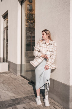 A Confident Young Girl With A Bionic Prosthesis Standing In The Street And Smiling.