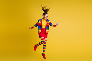 Full length photo of cheerful girl jump look copyspace wear rainbow skirt isolated bright color...