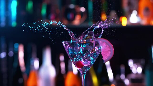 Camera Follows Ice cubes Falling into Glass of Fresh Fruit Cocktail in Bar. Super Slow Motion filmed on High Speed Cinema Camera.