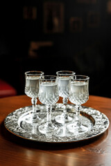 Different kinds of white vermouth in small liqueur glasses on a silver tray