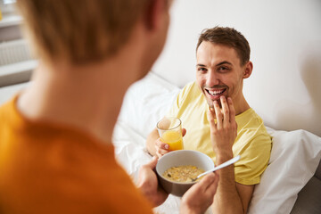 Loving young man bringing delicious breakfast to his boyfriend