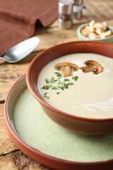 Delicious cream soup with mushrooms on wooden table, closeup