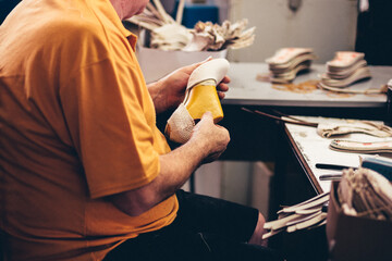 Manos trabajando en fábrica. Fábrica de calzado. Industria.	