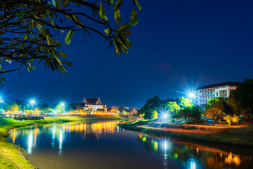 Fototapeta na wymiar light on the Nan River with court Phitsanulok province building at the Nan River and the park at night in Phitsanulok, Thailand.