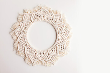 Macrame mandala. Macrame wreath on a white background close up. Natural cotton thread. Eco home...