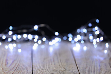 Beautiful lights on light wooden table, blurred view