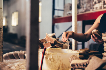Manos trabajando en fábrica. Fábrica de calzado. Industria.	