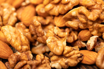 Almonds and walnuts scattered on the table. Close-up, selective focus.