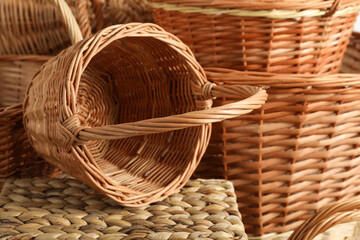 Many different wicker baskets made of natural material as background, closeup