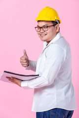 Industry worker or engineer working an architect builder studying layout plan serious civil engineer working with reading on blueprint isolated on pink blank copy space studio background,indoor studio