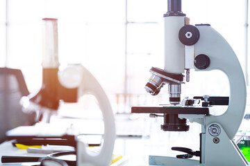 Microscope and test tubes with lab glassware in laboratory background, research and Scientific concept