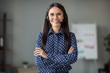 Photo of confident young call center worker woman hold arms folded wear glasses headphones microphone indoors in office - obrazy, fototapety, plakaty