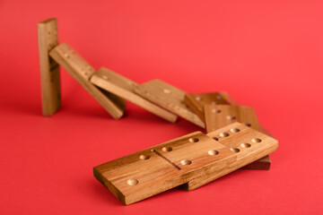 Wooden domino tiles falling on red background