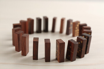 Wooden domino tiles with golden pips on white table