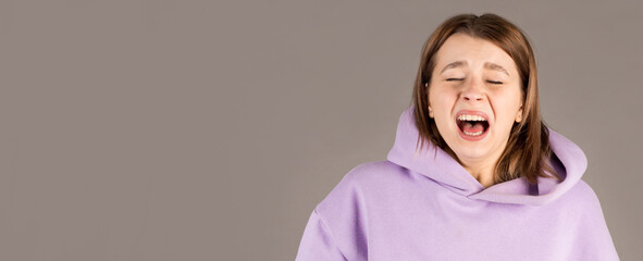 Young funny woman sneezing studio portrait on gray background. Comic, caricature, humor. illness,...