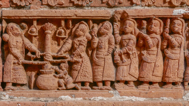 Ladies churning milk and baby Krishna waiting for butter : terracotta carving at Kantaji aka Kantajew medieval hindu temple in Kantanagar, Dinajpur, Bangladesh