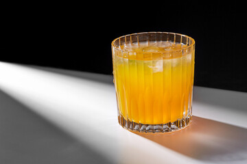 drink, detox and vitaminic concept - glass of orange juice or lemonade with ice on table