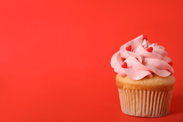 Tasty cupcake on red background, space for text. Valentine's Day celebration