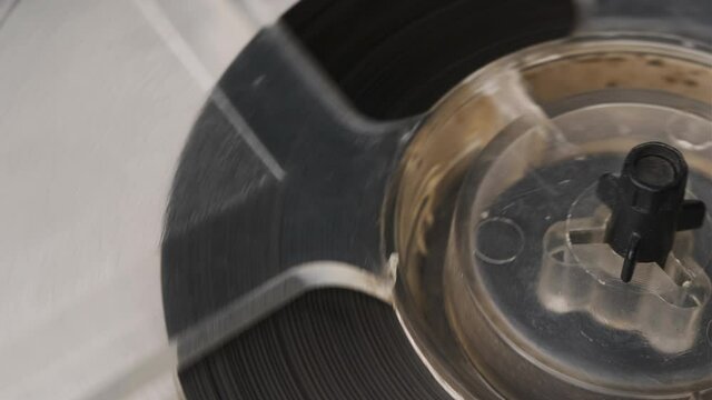 Old fashion vintage reel tape recorder. Reel film tape rotating vintage professional player. Extreme close up of spool of music player.