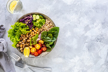 Quinoa, mushrooms, lettuce, red cabbage, spinach, cucumbers, tomatoes, a bowl of Buddha on a white background, top view. Delicious balanced nutrition concept