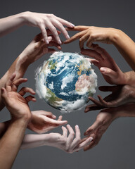 Hands holding, touching planet Earth, close up on grey background. Environment save, taking care of...