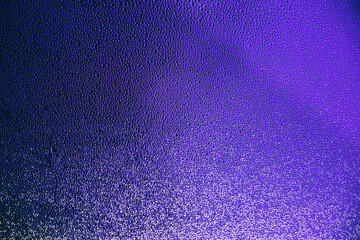 Abstract water drops on glasses window neon violet purple colored gradient background. Wallpaper.