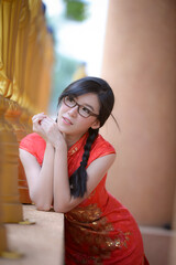 Fototapeta premium Action portrait beautiful Asian girl wearing Cheongsam green dress. the celebration of something in a joyful and exuberant way. Festivities and Celebration concept