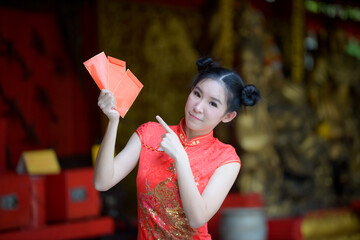 Obraz na płótnie Canvas Action portrait beautiful Asian girl wearing Cheongsam red dress. the celebration of something in a joyful and exuberant way. Festivities and Celebration concept