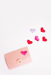 Lovers envelope with colorful hearts. Valentine's Day 2021 message. 14 February greeting card. Pink pastel envelope on white background. Stories for Valentine's Day. High quality photo