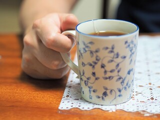 ティーカップを持つ男性の手