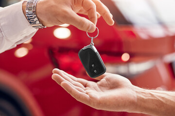 Crop customer taking rent keys from car dealer