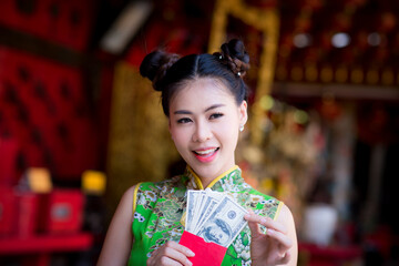 Action pictures of beautiful Asian girls wearing red cheongsam To celebrate something with a fun festival and shopping