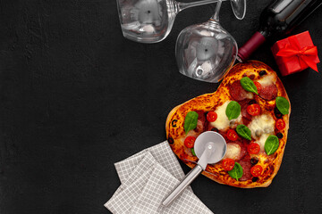 Valentine's day table setting. Heart pizza with wine, glasses and gift box