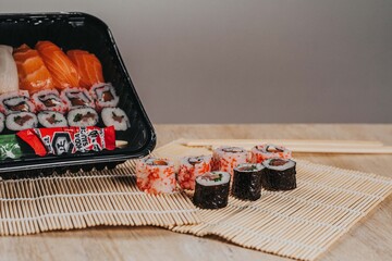 Sushi. Comida japonesa sobre esterilla. Foto de nigiri y maki sushi con luz lateral. Composición de comida asiática.	