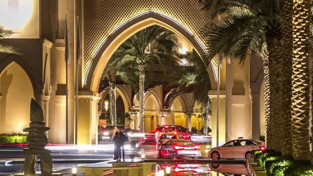 Entrance of Hotels with arch, offices and Souk in downtown night timelapse hyperlapse in Dubai, UAE Palms and reflections in water of fountain pool