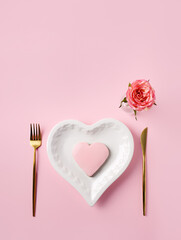 Romantic table setting for Valentines day. Love layout made with golden spoon and fork, heart...