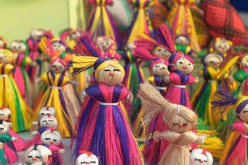 Vibrant multicolor jute dolls, used as wall hanging puppets in a retail display for sale at a...