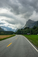 Fototapeta premium Road through a valley with clouds at the mountains