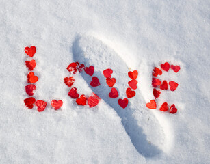 valentine's day concept: word love laid out with hearts on snow