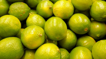 lots of round ripe green limes side view . background of green citrus