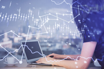 Double exposure of businesswoman hands typing on computer and forex chart hologram drawing....