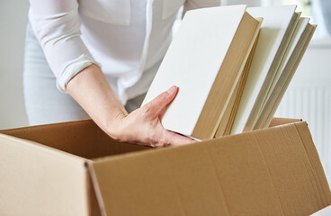 Woman unpacks books from a moving box