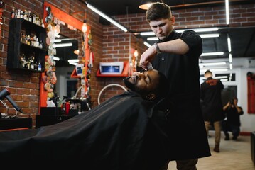 Visiting barbershop. African American man in a stylish barber shop