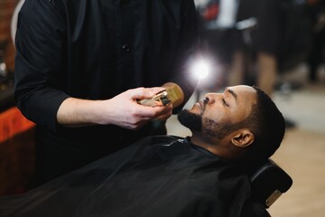Visiting barbershop. African American man in a stylish barber shop